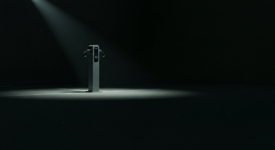 A lone electric scooter fast charging point lit by a single overhead light on a dark forecourt