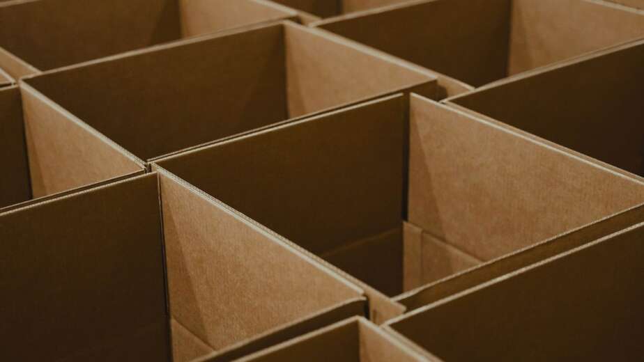 Rows of stacked cardboard shipping cartons on dark warehouse shelving, the marketplace channel Indian D2C brands actually sell through