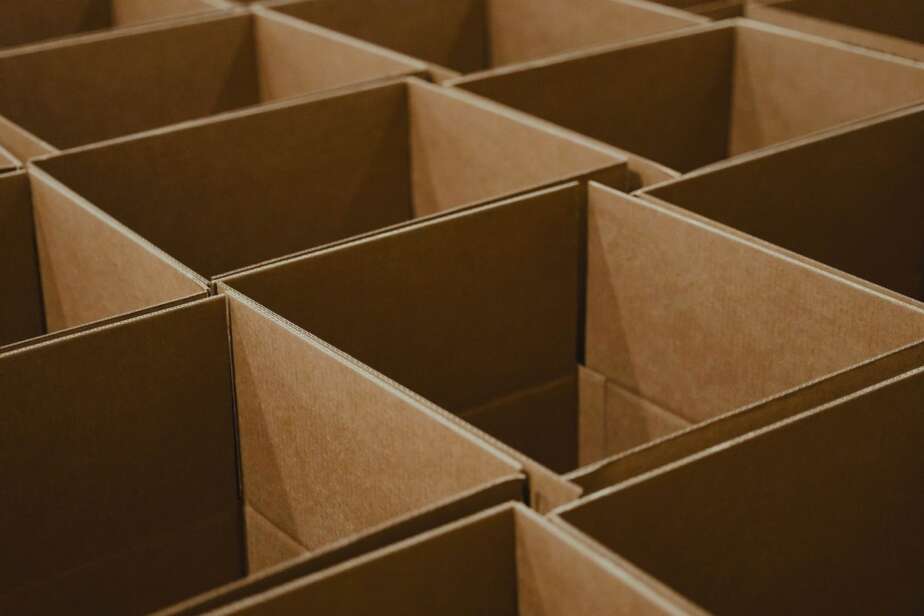 Rows of stacked cardboard shipping cartons on dark warehouse shelving, the marketplace channel Indian D2C brands actually sell through
